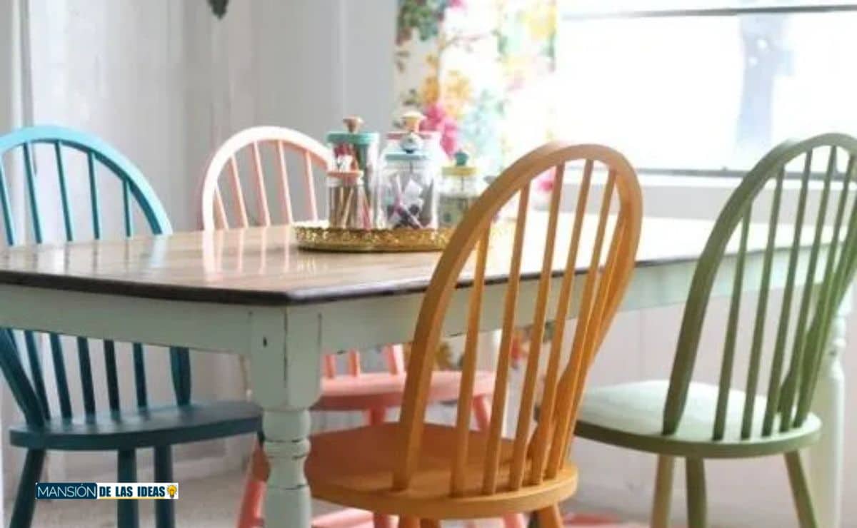 Cocina con sillas de colores y una mesa de madera al estilo del cielo claro